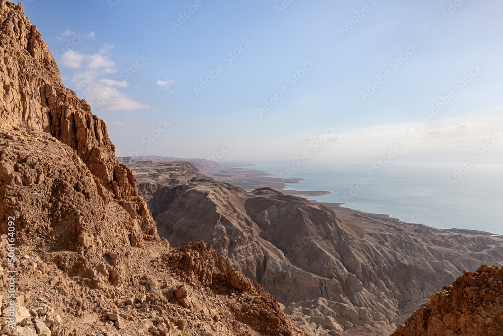 Obraz premium Sunrise over the Dead Sea near mountains of stone desert near the Khatsatson stream, on the Israeli side of the Dead Sea, near Jerusalem in Israel