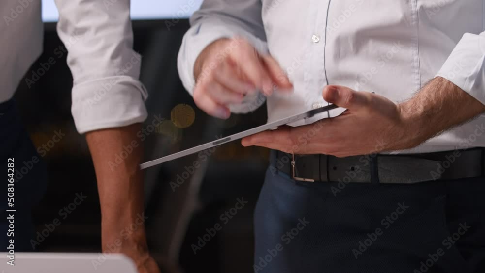 Two businessmen with a tablet discussing a business project in the office Two businessmen with a tablet discussing a business project in the office