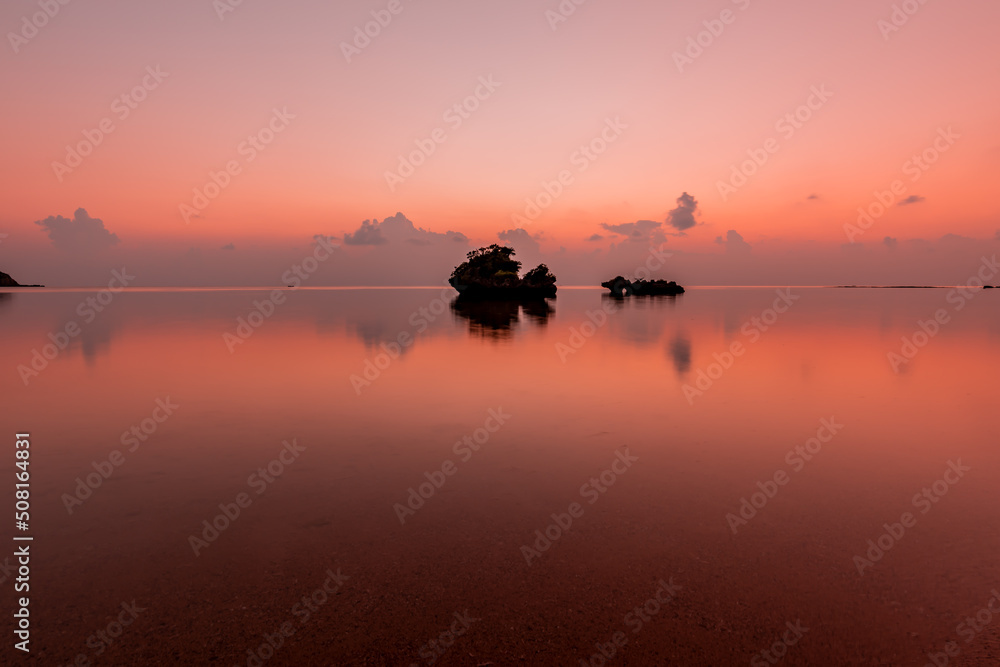 Gorgeous seascape at dusk, islets in silhouette in a pink shades sea.