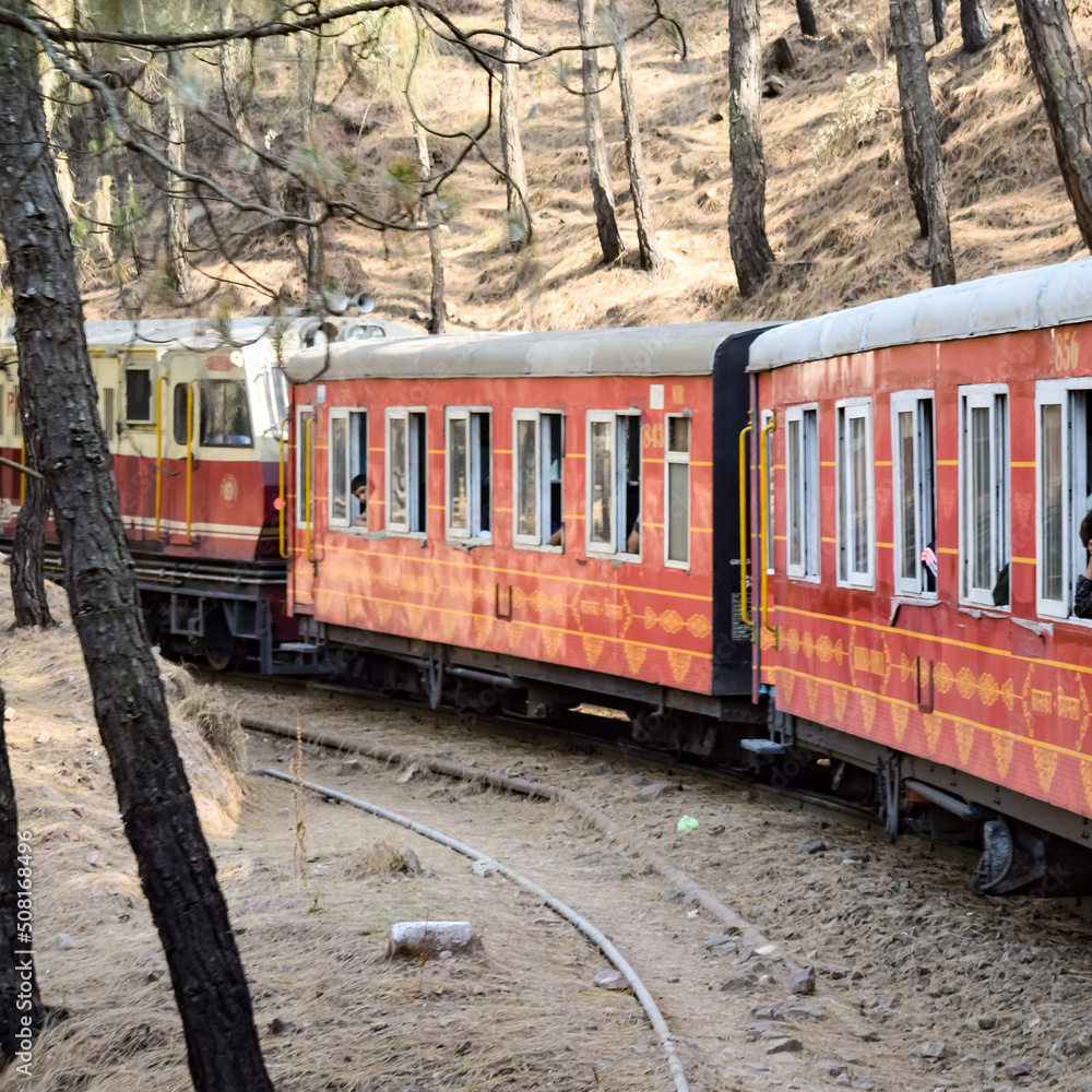 Toy Train moving on mountain slopes, beautiful view, one side mountain, one side valley moving on railway to the hill, among green natural forest. Toy train from Kalka to Shimla in India Toy Train moving on mountain slopes, beautiful view, one side mountain, one side valley moving on railway to the hill, among green natural forest. Toy train from Kalka to Shimla in India