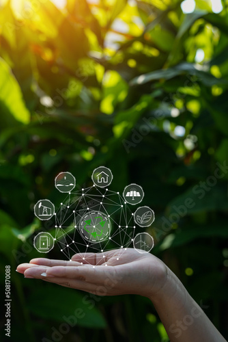 Technology  hand holding with environment Icons over the Network connection on green background