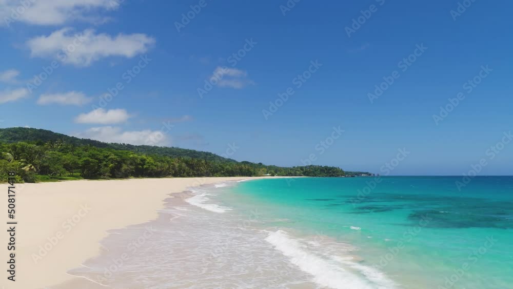 Turquoise sea waves on an exotic sandy beach on a sunny day. Summer on the tropical coast. Relaxation at sea. Cruise. Landscape of a wild beach. Beautiful seascape. Bright blue sky over the sea. Turquoise sea waves on an exotic sandy beach on a sunny day. Summer on the tropical coast. Relaxation at sea. Cruise. Landscape of a wild beach. Beautiful seascape. Bright blue sky over the sea.