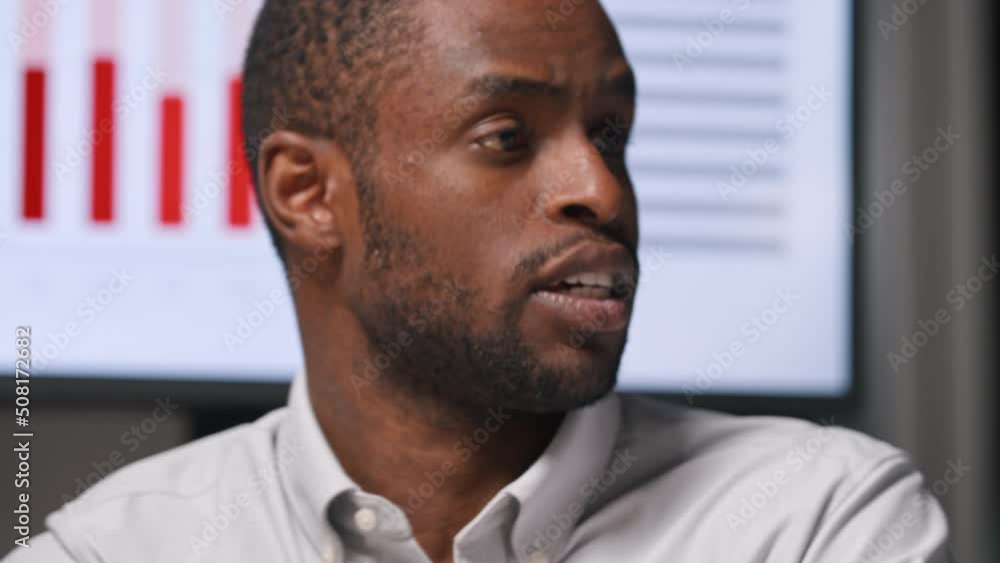 Young african american businessman working with statistics using tv multimedia in the evening Young african american businessman working with statistics using tv multimedia in the evening