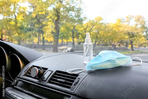 Bottle of sanitizer and medical mask in car