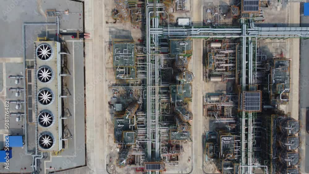 Aerial view of an oil refinery, chemical plant, or power plant with several storage tanks and pipelines from above. Drone footage in 4K resolution.