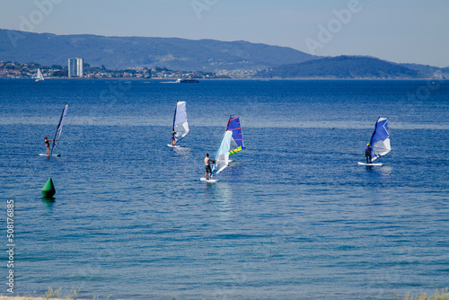 surfers with windsurf board in the sea