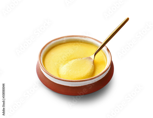 Ghee or clarified butter in a ceramic bowl, spoon full of yellow ghee photo