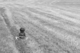 Jeune enfant assise en train de bouder dans un champ