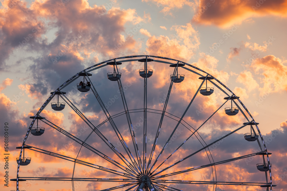 Ferris Wheel with clouds in sky, dramatic sunset cloudscape
