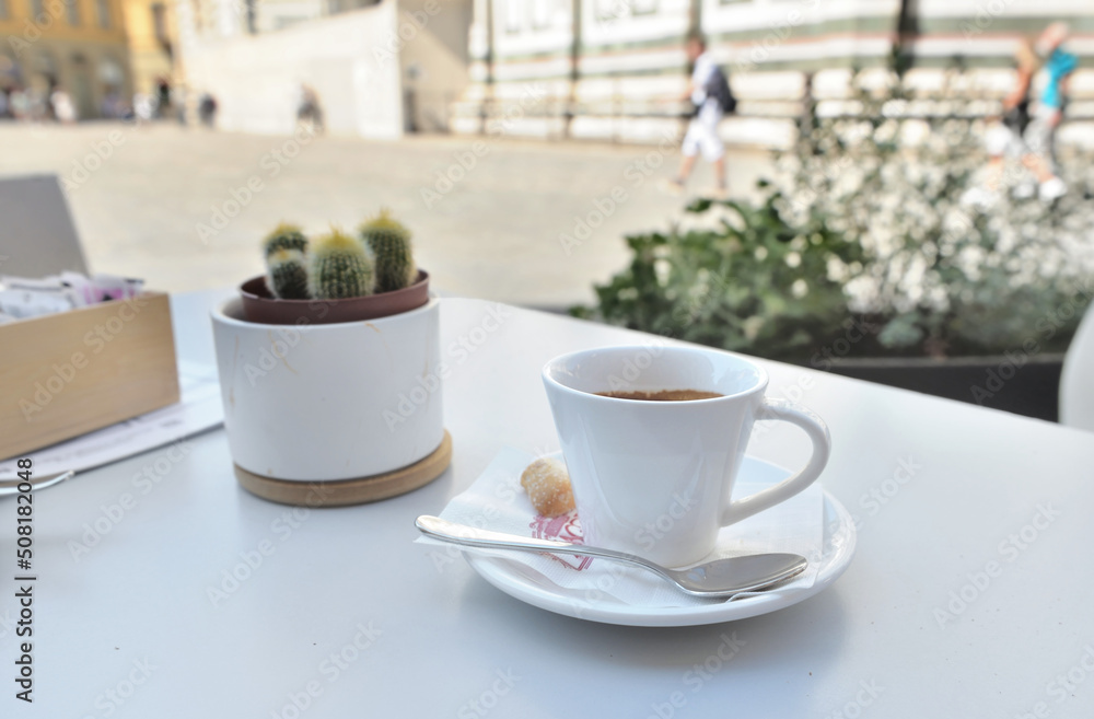 cup of coffee on a table in terrace with a potted plant in the square of Duomo in Firenze cup of coffee on a table in terrace with a potted plant in the square of Duomo in Firenze