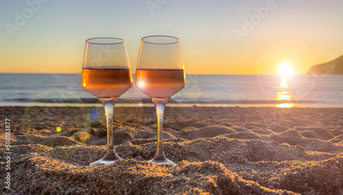 wineglasses on the beach at sunset photo