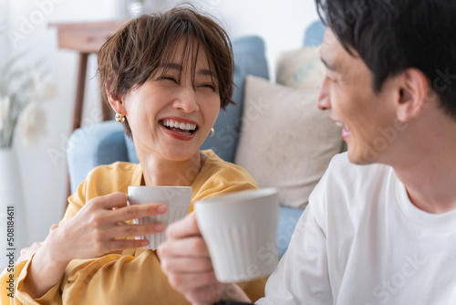部屋でくつろぎながら笑う仲良し若い日本人カップル・夫婦
