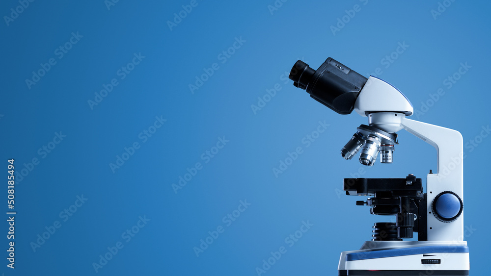 Professional laboratory microscope on blue background