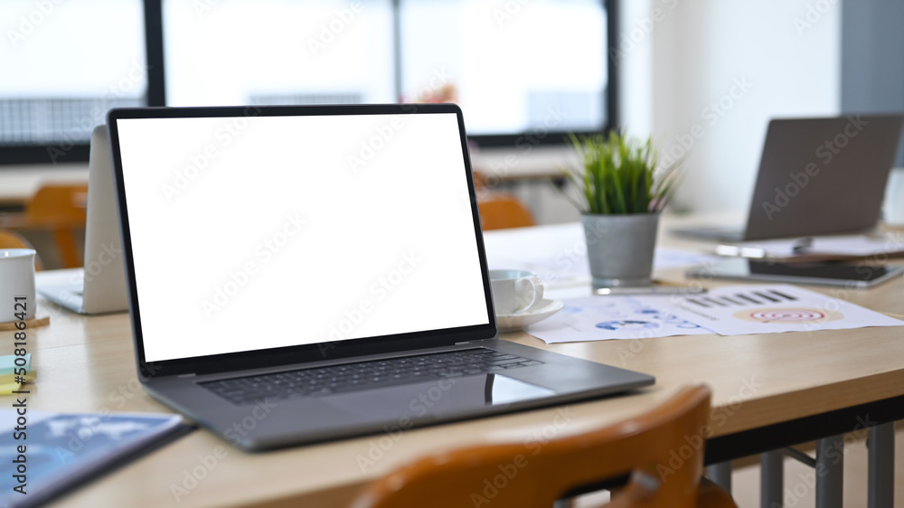 Fototapeta premium Mock up laptop computers, financial reports, potted plant and coffee cup on wooden office desk