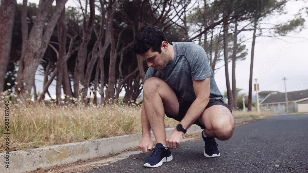 Caucasian man on a run stops to tie his shoelaces. Caucasian man on a run stops to tie his shoelaces.