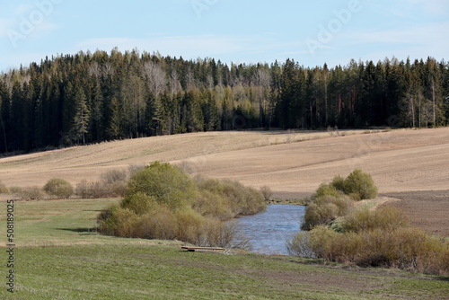Springlike river flowing through fields