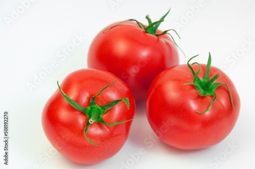 ripe tomatoes on a white background. the concept of cooking tomato sauce. red vegetables on a light texture. juicy pink tomatoes on the table