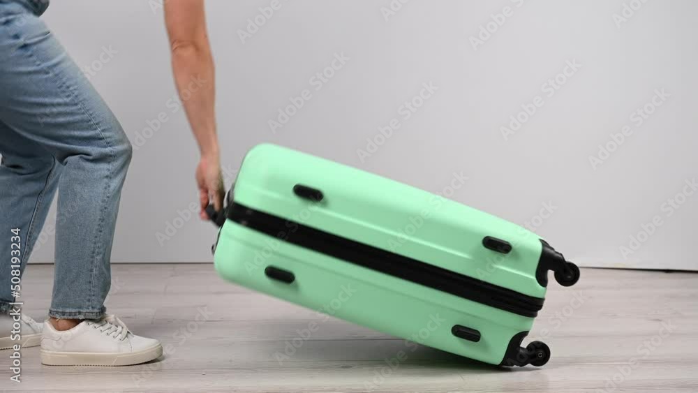 The woman puts her luggage bag on the floor and jumps from above. The