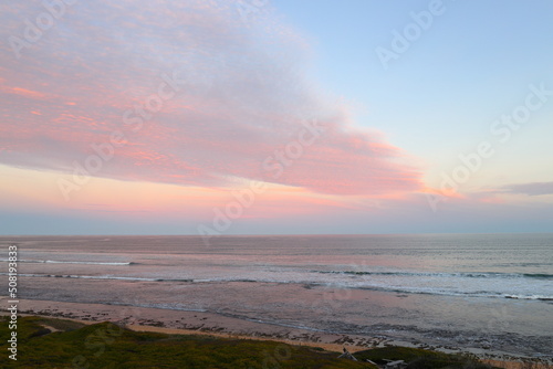 A sunset view over the coastline at Witsand  South Africa  with pink clouds and blue skies.