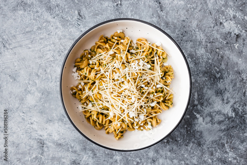 healthy plant-based food, vegan spinach and dairy-free cheese pasta bowl with wholemeal spirals