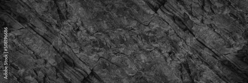 Black white rock texture. Rough mountain surface. Close-up. Stone background with space for design. Web banner. Wide. Panoramic.