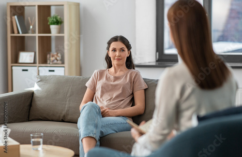 psychology, mental health and people concept - young woman patient and woman psychologist at psychotherapy session