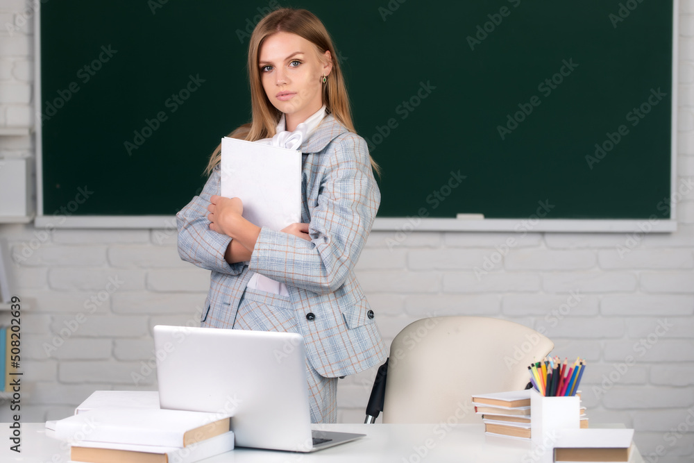 Positive smart young female freelancer or a student with book. Female student on lesson lecture in classroom at high school or college. Positive smart young female freelancer or a student with book. Female student on lesson lecture in classroom at high school or college.