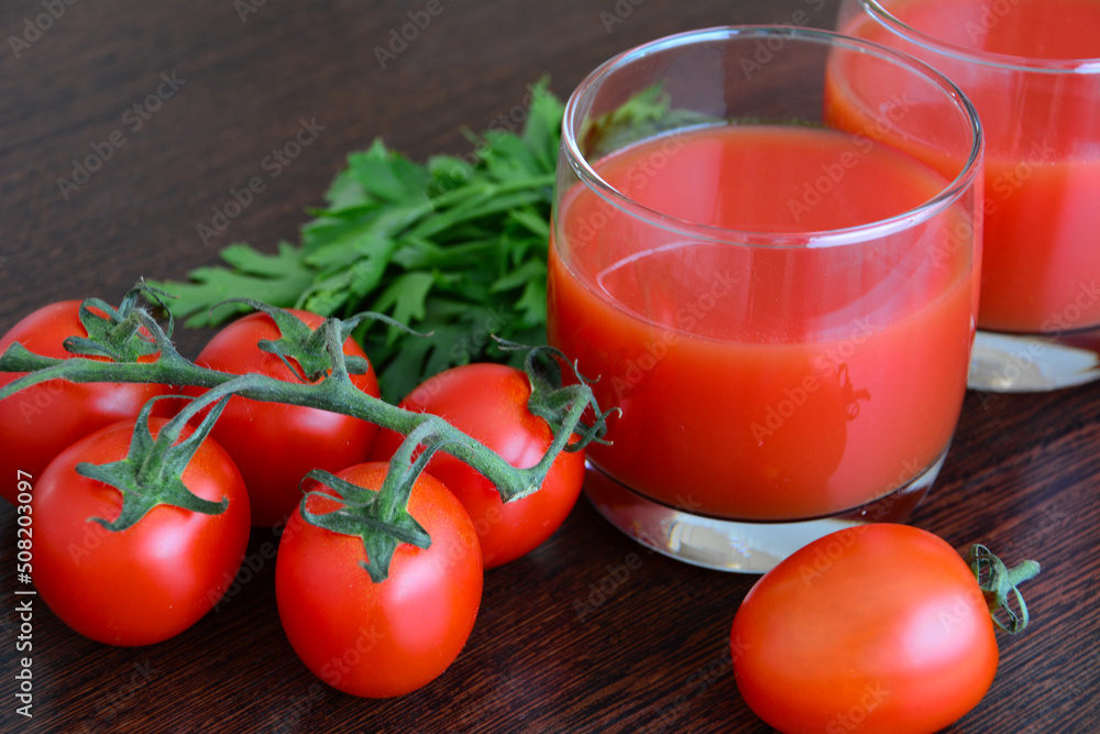 fresh tomato juice in drinking glasses decorated with cherry tomatoes on dark background fresh tomato juice in drinking glasses decorated with cherry tomatoes on dark background