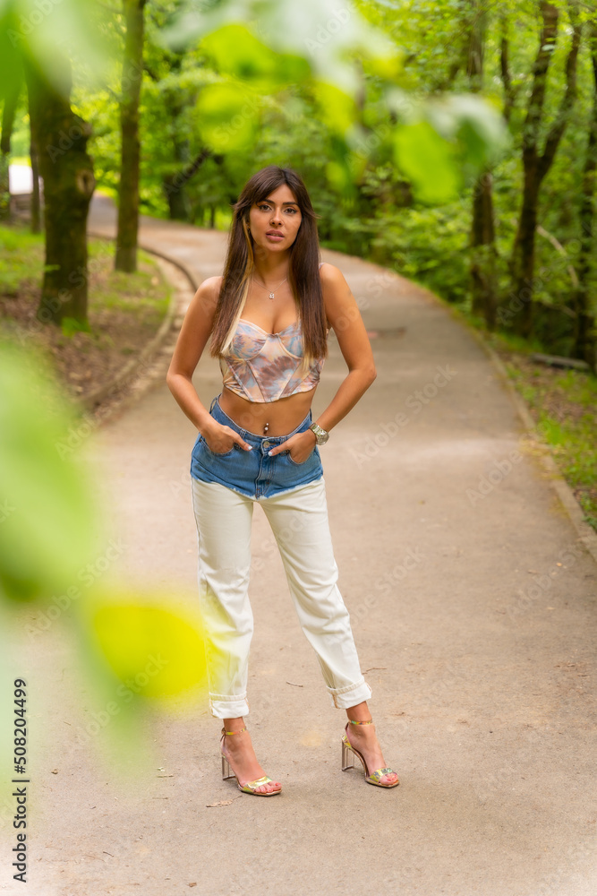 Portrait of a Caucasian girl on a path in a city park, fashionably posed in nature, walking in the park Portrait of a Caucasian girl on a path in a city park, fashionably posed in nature, walking in the park