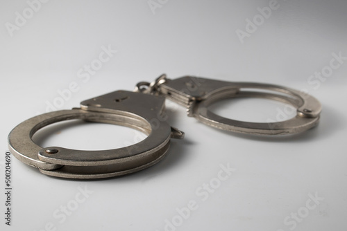 Metal handcuffs with a chain on a light background