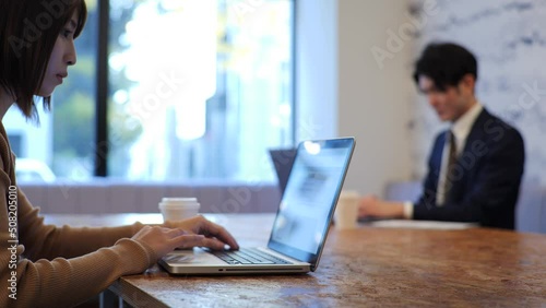 ノートパソコンで仕事をする日本人のビジネスイメージ