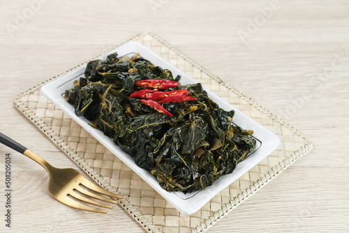 Stir Fry Papaya Leaves or Tumis Daun Pepaya, a traditional Indonesian dish made from boiled papaya leaves stir-fried with spices and chilies.
 photo