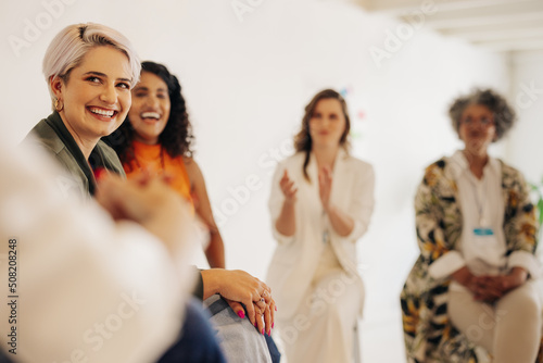 Businesswomen applauding their colleague during a meeting