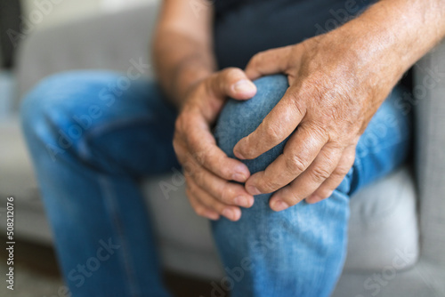 Valokuva Senior holding his painful knee