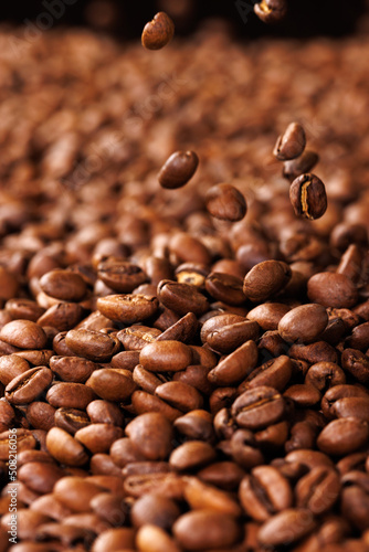 Vertical background of coffee beans close-up. Selective focus.