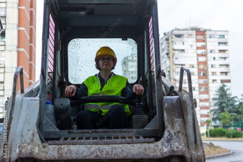 cheerful female excavator operator on construction site. Woman