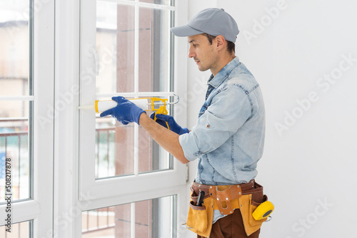 The worker installing and checking window in the house