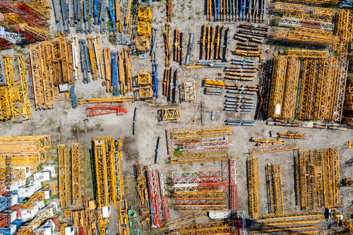 Storage place of high-rise cranes. Aerial view of yellow elements, industrial technology.