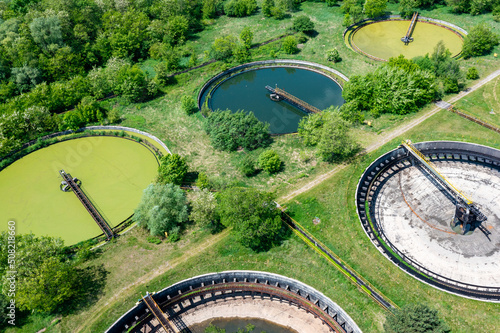 Sewage farm. Aerial photo looking down onto the clarifying tanks and green grass. Top view of sewage treatment plant. Industrial Technology. 