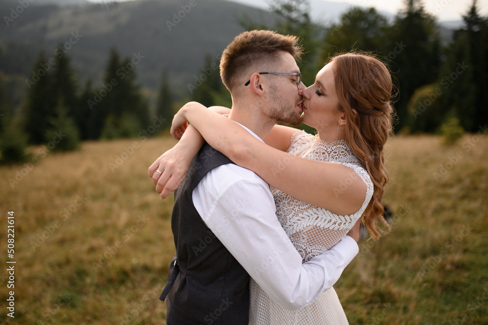 happy stylish bride and groom running and having fun in mountains on summer sunny day happy stylish bride and groom running and having fun in mountains on summer sunny day