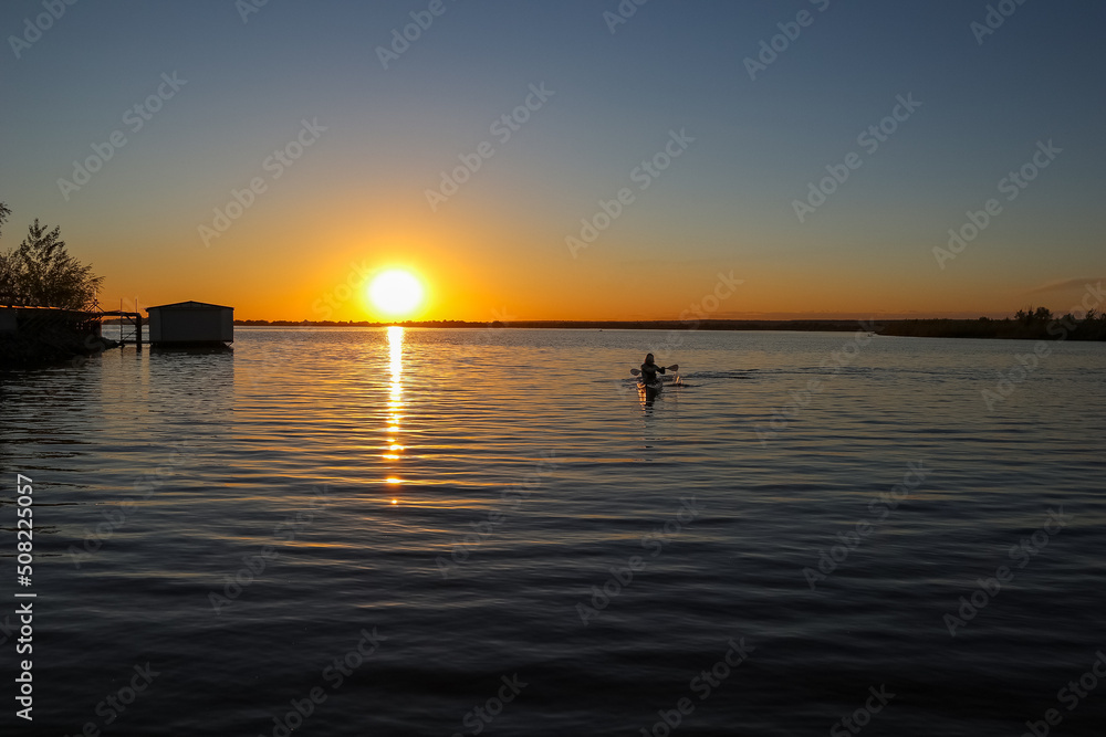 forces a guy swimming in a kayak at sunset. water sports. summer vacation on the water forces a guy swimming in a kayak at sunset. water sports. summer vacation on the water