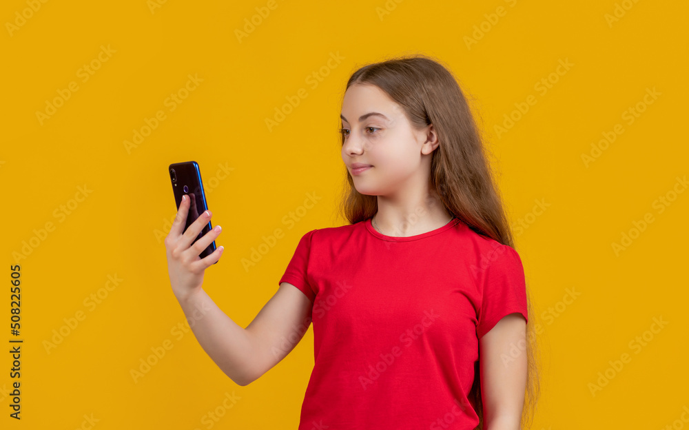 smiling child with smartphone on yellow background