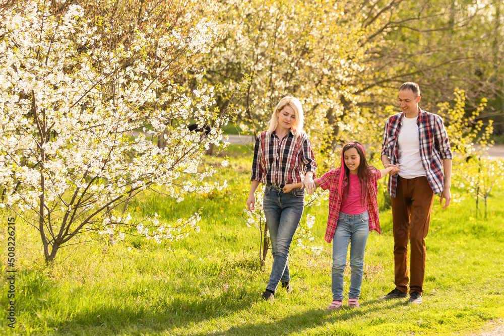 Happy family spending good time together in spring in a flowering garden Happy family spending good time together in spring in a flowering garden