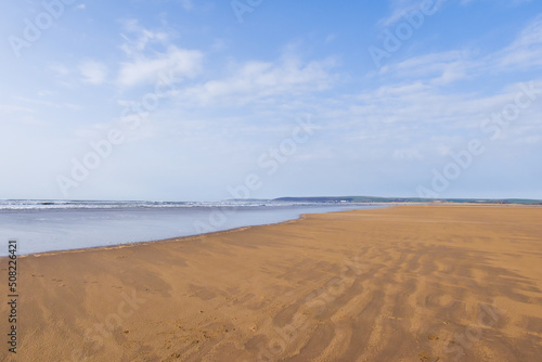 Wide angle view of empty beach with expanse of sand