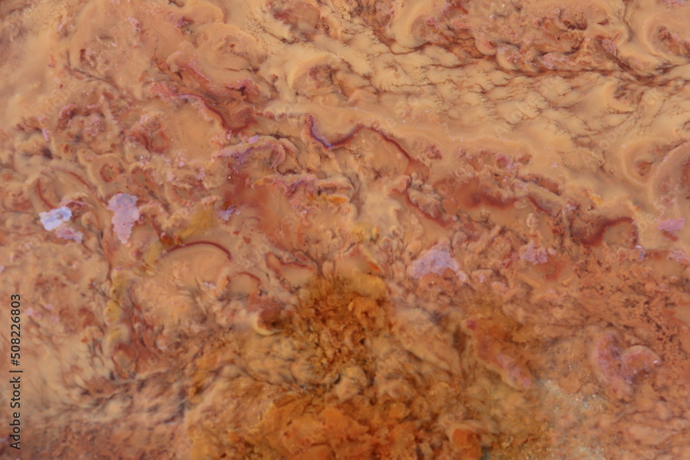 orange precipitate which indicates the water contains iron. form a beautiful background. orange precipitate which indicates the water contains iron. form a beautiful background.