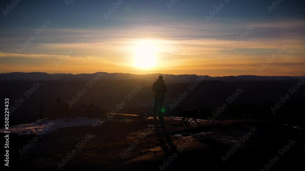 Sunset over a mountain in Norway. Man and dog. Hero shot. Drone Sunset over a mountain in Norway. Man and dog. Hero shot. Drone