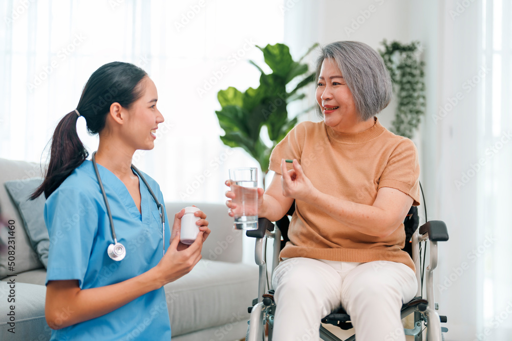 Female caregiver giving the medicine to her older female patient. Female caregiver giving the medicine to her older female patient.