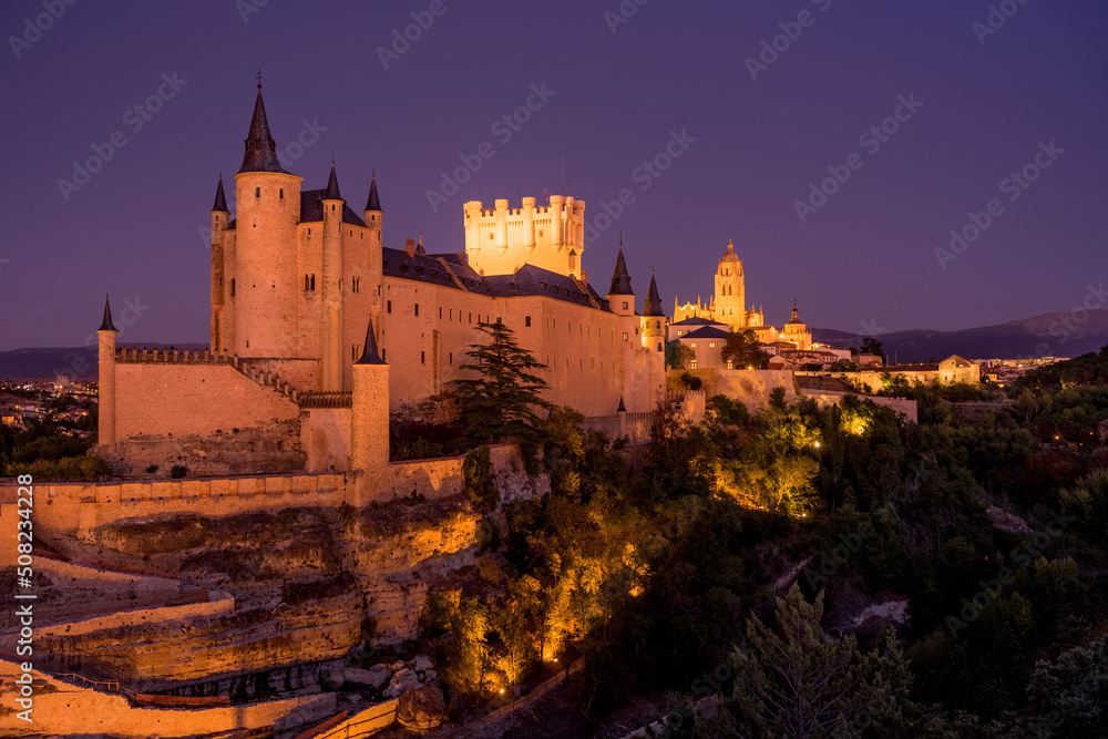 View of the Alcazar fortress and St Mary cathedral of segovia illuminated at night, listed world Heritage centre by UNESCO
