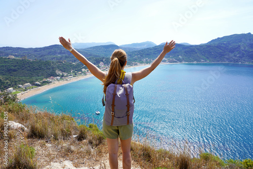 Successful hiking woman on top of mountains, motivation and inspiration in beautiful panoramic view. Female hiker with arms up outstretched on mountain top, inspirational landscape.