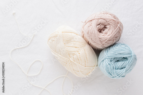 Balls of cotton yarn pastel colors on a white table